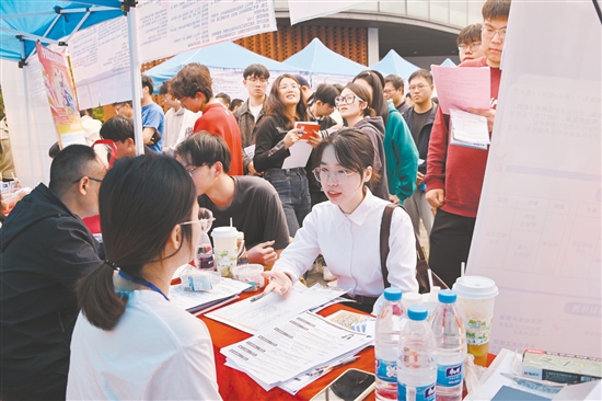招聘会现场人头攒动，不少企业摊位前排起了长队。
