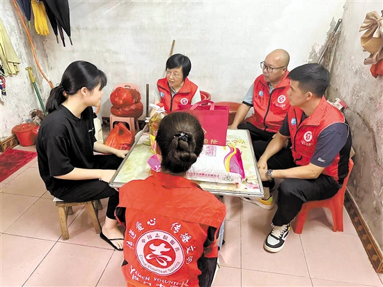张艳玲（上）组织本单位党员积极参与“爱心父母”活动。