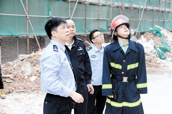 冯德明（左一）联合消防部门对小区消防安全进行检查。