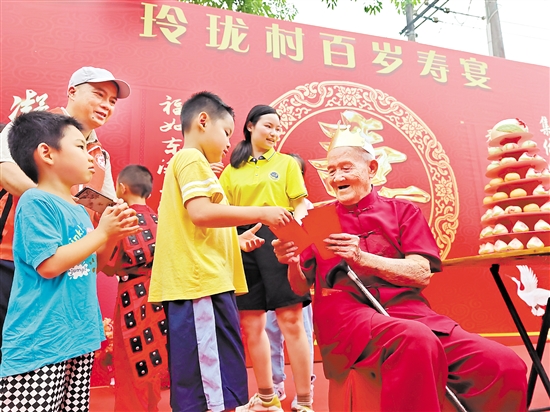 梁如旺为现场参加活动的小朋友发红包。