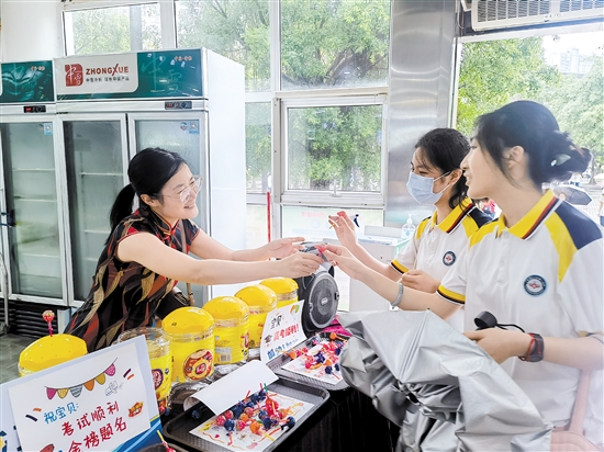 江门一中考点在学校食堂设置了暖心“服务台”，工作人员现场给高三学子派发棒棒糖，送上祝福和鼓励。江门一中供图