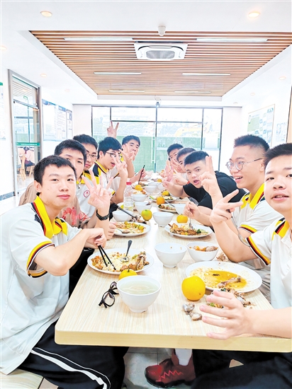 礼乐中学考生们在就餐，食堂随餐附送橙子，寓意“心想事成”，祝福考生考试顺利，“橙”心如意。