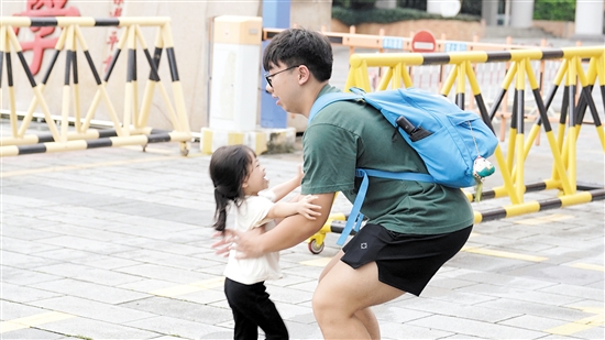 江门一中考点，小女孩兴高采烈地迎接走出考场的哥哥。