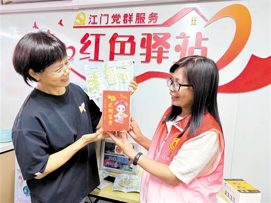 市民在红色驿站内领取附有二维码的精品旅游线路图和打卡礼品，实现“一码游礼乐”。