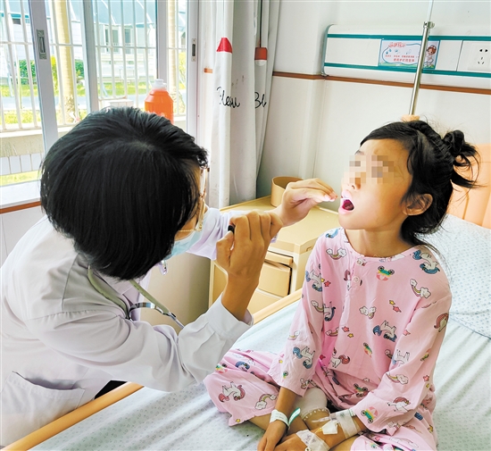 儿科医生为手足口病患儿检查身体情况。