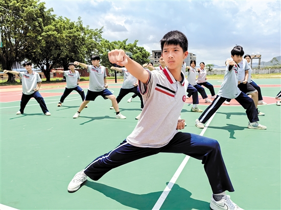 恩平市江南学校的龙狮队队员在崭新的运动场上训练。