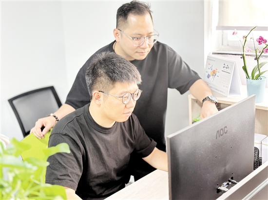 胡宝鹏（右）与深圳的同事一起探讨产品研发相关问题。
