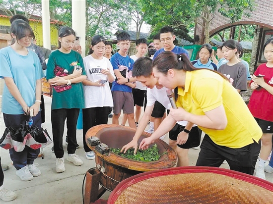 学生们在研学活动中体验炒茶。