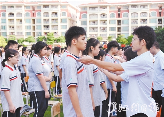 恩平市鳌峰中学老师们为学生正衣冠。