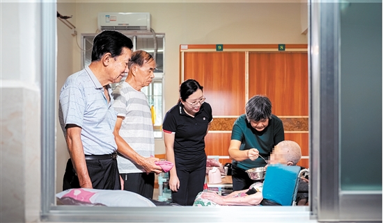 “邑康保”工作人员探望生病的参保人。