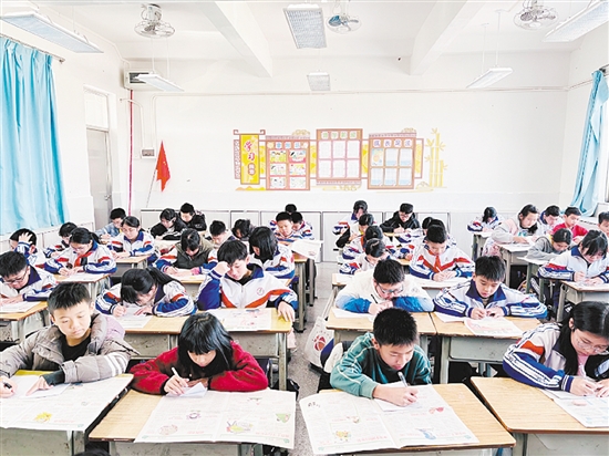 大鳌镇特沙小学学生在老师的带领下读报。