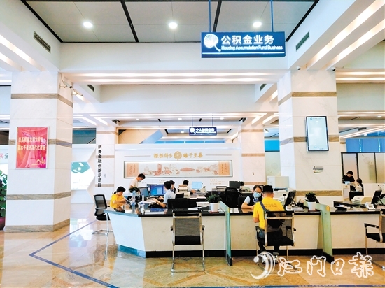 建行江门市分行营业厅内，工作人员为客户办理业务。