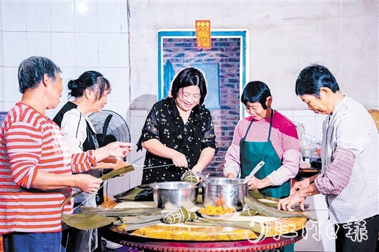 非遗传承人吕艳卿正在传授柴火粽的制作技艺。