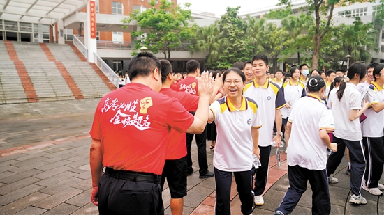 老师们与高考学子们击掌鼓劲。