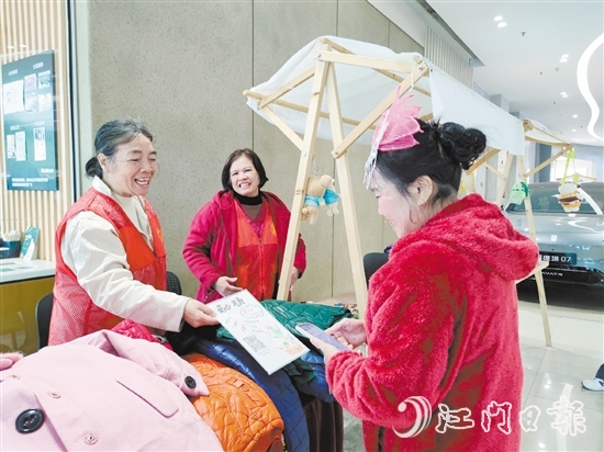 志愿者霞姐的衣物摊位吸引了不少顾客前来选购。