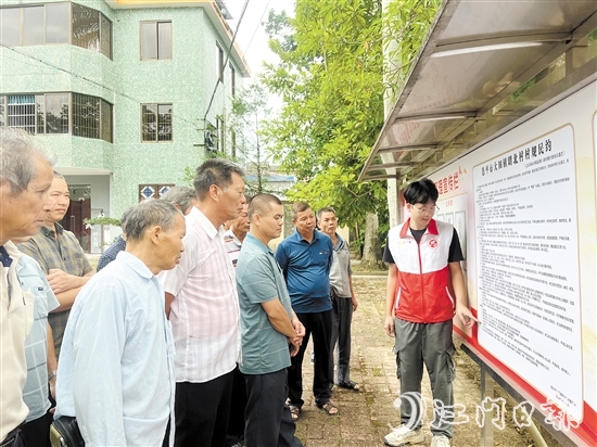 大田镇朗北村新时代文明实践站志愿者向村民介绍村规民约的内容。