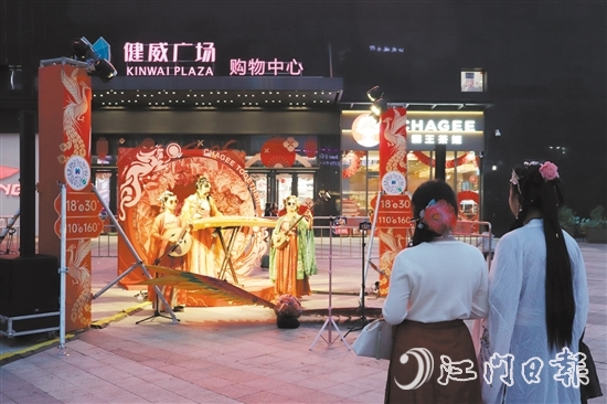 在健威广场，身穿汉服的市民驻足欣赏国潮音乐表演。