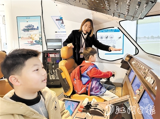 学生在工作人员的指引下体验中国商飞C919模拟驾驶。