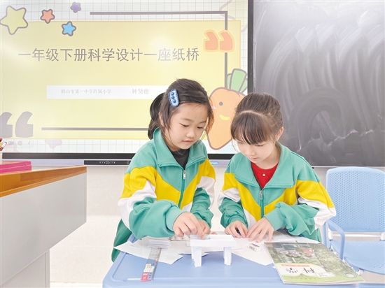 在“搭纸桥”实验中，学生们利用日常生活中常见的纸张，专注地探索纸桥的承重奥秘。