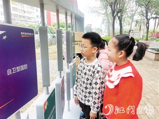 主题公园新设置的互动展板吸引周边小学生学习国防知识。