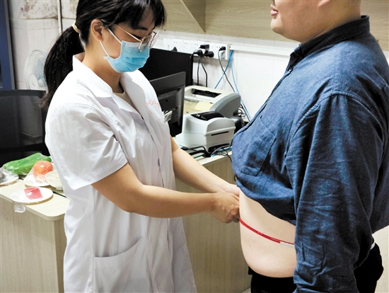 医生为记者测量腰围。