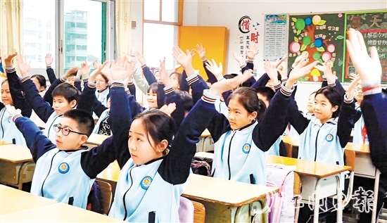学生们在课桌前跟随节奏做起“室内课桌操”。