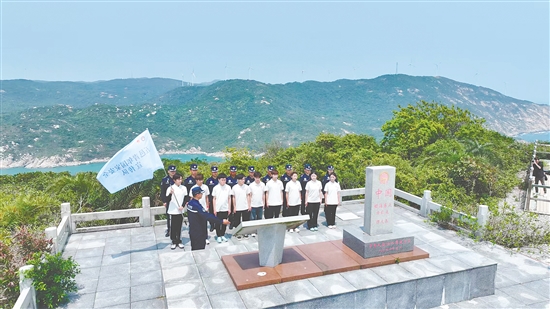 江门市青年学生国家安全志愿者宣传队成员在江门围夹岛领海基点为领海界碑描红。