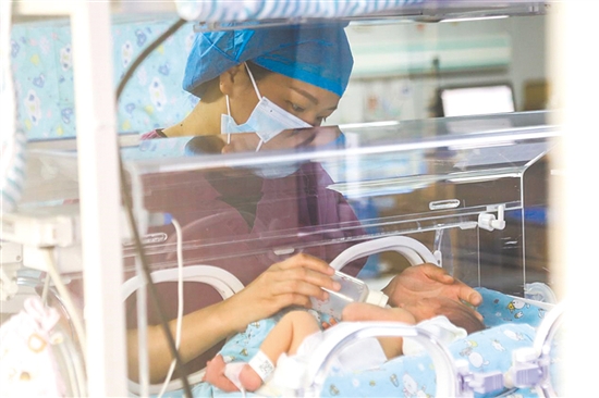 这是一双小心翼翼的手。在江门市妇幼保健院新生儿科，护士李丽婷化身临时“奶妈”，手持奶瓶给早产儿喂奶。她时而调整奶瓶角度，时而放缓速度，用耐心与爱心为小生命构筑温暖港湾，陪伴他们跨越成长路上最初的难关。