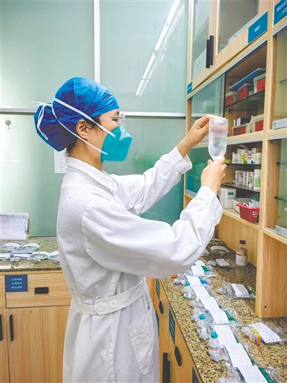 这是一双严谨可靠的手。输液前核对和检查药物的步骤是护理操作中的关键环节，要遵循“三查七对”原则。此时，江门市结核病防治所住院部护士黄惠敏正在认真核对患者的输液药物，确保用药安全。