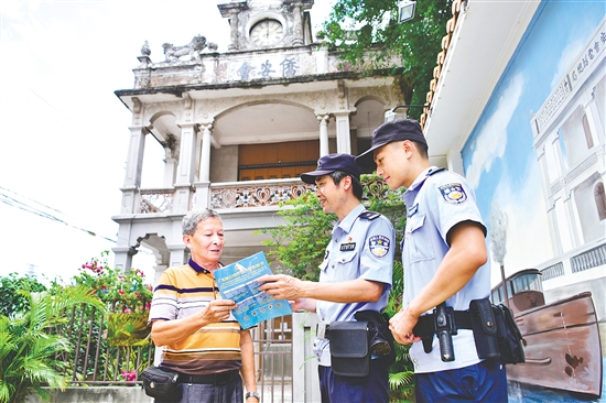 沙堆派出所民警向群众派发宣传资料。