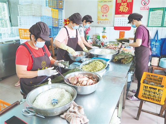文龙甜品粽子店工人正在包粽子。