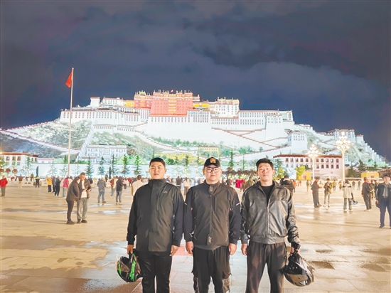 余鸿威（左一）与摩友在拉萨布达拉宫前合影留念。