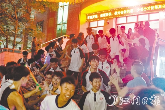 高一高二学生齐聚校道两旁，为即将高考的高三学长学姐送上祝福。