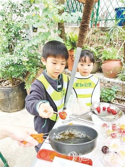 孩子们用自己采收的甘蔗熬糖水制作糖葫芦，感受劳动的乐趣。
