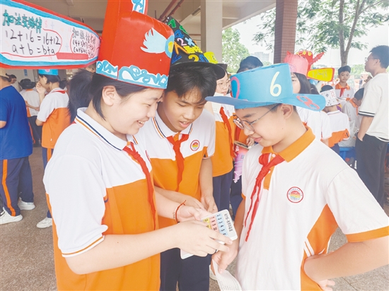 学生们戴着“数学帽”穿梭在各个游戏摊位间，形成一道亮丽的风景线。