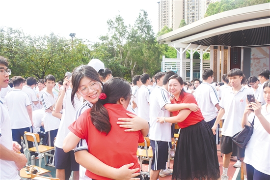 在纪元中学的2025届高三毕业典礼上，教师与毕业生击掌、拥抱。
