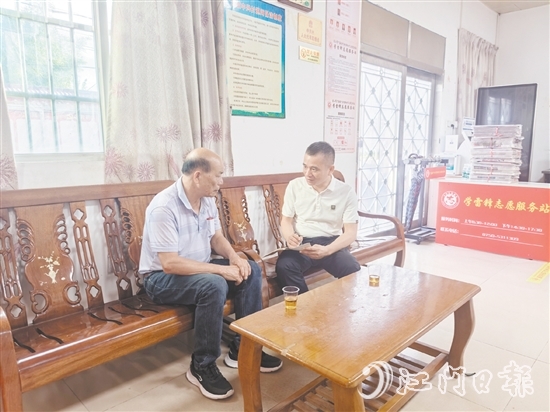 罗坚济（右）耐心地为群众做法律科普。