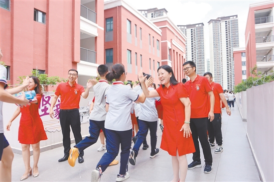 蓬江区紫茶中学的领导和老师们与考生们击掌，为他们加油、鼓劲。