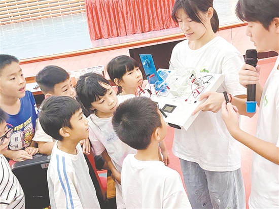 服务队队员向孩子们展示氢燃料电池演示仪。