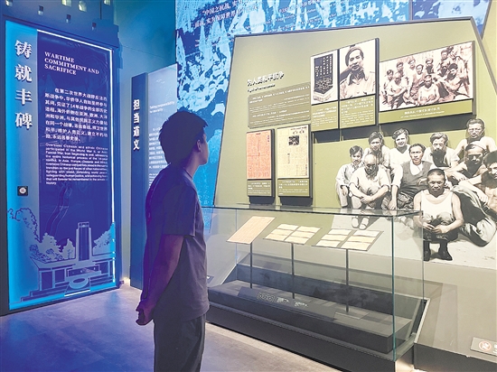 在侨博馆“铸就丰碑”展示区，参观者通过图文、实物等回顾海外侨胞的抗战故事。