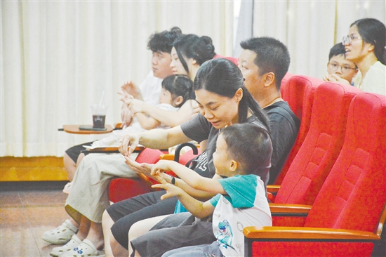 家长在听讲座时，根据医生的讲解在练习推拿。