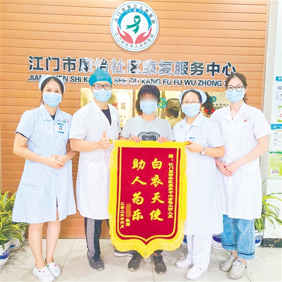 李明给康复中心医护人员送上锦旗。