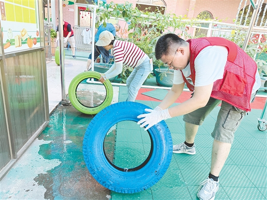 蓬江区委组织部干部深入幼儿园清理轮胎内积水，做好基孔肯雅热疫情防控工作。