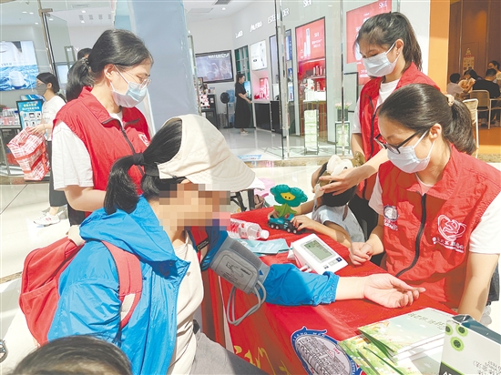 活动现场，医护人员为市民量血压。