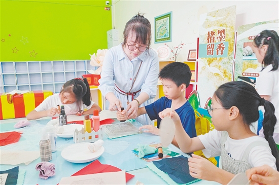 在导师的指导下，孩子们纷纷拿起纸张，在拓板上谨慎操作。