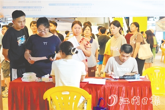 活动现场，求职者手持简历与企业招聘人员进行交流。