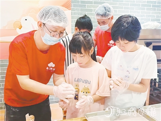 小学员们在师傅手把手的指导下认真学习制作冬蓉月饼。