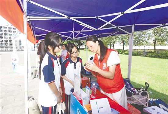 工作人员向新入学学生介绍医保线上办事流程。