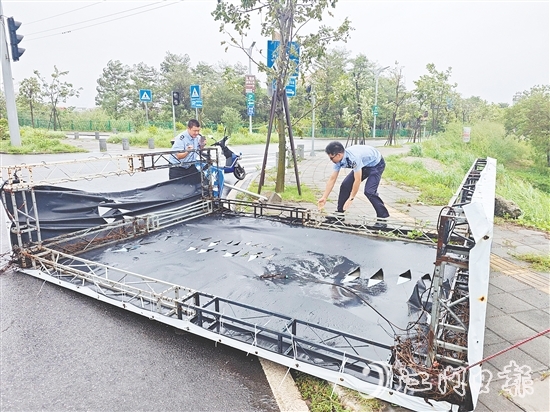 民辅警清理翻倒的广告牌,确保群众出行安全。 民辅警清理翻倒的广告牌,确保群众出行安全。