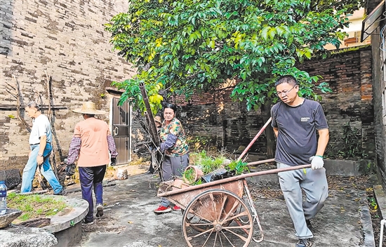 村民合力整治卫生黑点，清运堆积杂物。